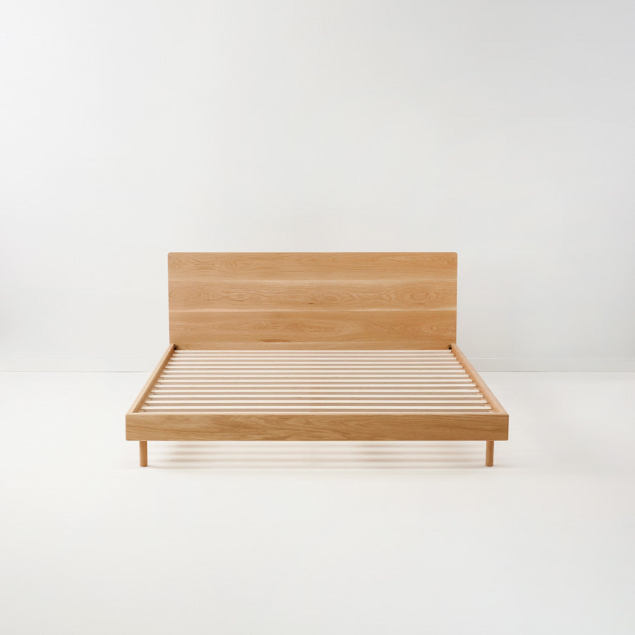 Leni solid timber bed frame with sculptural headboard in a minimalist bedroom